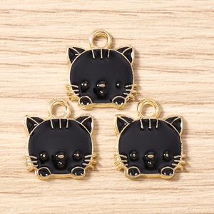 Detaillierte Ansicht von drei schwarz-goldenen Emaille-Katzenanhängern für DIY-Schmuck