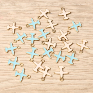 Detalle de dijes de avión en esmalte azul claro y crema para la creación de joyas DIY