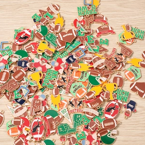 Detailaufnahme verschiedener American Football Emaille-Anhänger und Rugby-Charms auf Holz