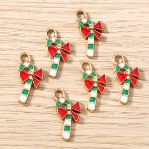 Christmas candy cane pendants with red bows for jewelry making on wood background
