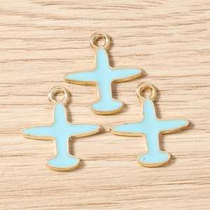 Primer plano de colgantes de avión en esmalte azul y borde dorado para joyería DIY