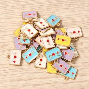 Détail de breloques enveloppes en émail coloré avec coeurs rouges pour création de bijoux