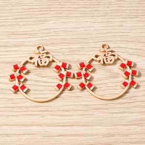 Gros plan sur des pendentifs dorés caractère Fu et pétards rouges pour bijoux DIY