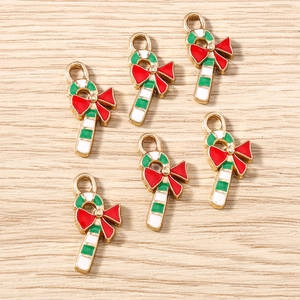 Detail of Christmas candy cane pendants with red bows and enamel finish for jewelry making
