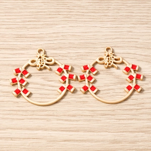 Détail de pendentifs pétards en émail rouge avec caractères Fu dorés pour la création de bijoux