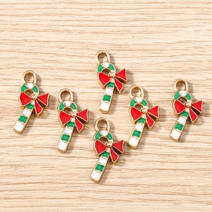 Detailed view of enamel Christmas candy cane charms with red bow for DIY jewelry making