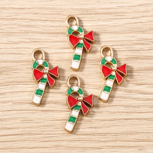Close-up of enamel candy cane charms with festive red ribbons for DIY jewelry making