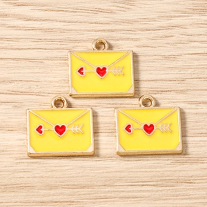 Détail de breloques enveloppes jaune émaillé avec bordure dorée pour bijoux DIY