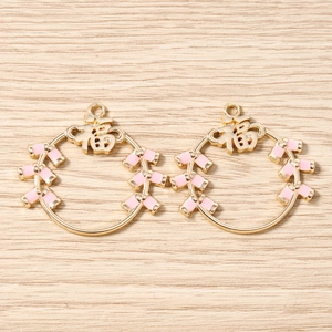 Détail des pendentifs Fu dorés avec émail rose pour la création de bijoux artisanaux