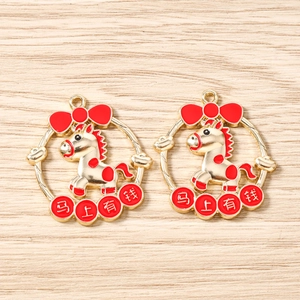 Détail de pendentifs cheval dorés avec nœud rouge et caractères de chance chinois