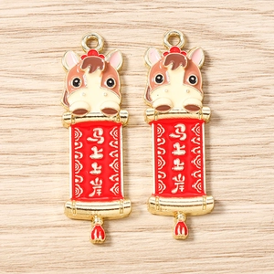 Détail du pendentif cheval doré avec parchemin rouge et pompon pour bijoux DIY