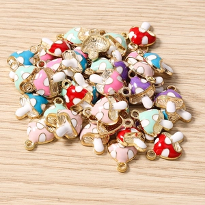 Vista macro de colgantes de setas en esmalte colorido con reverso dorado para joyas DIY
