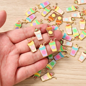 Gros plan de breloques émaillées thé au lait colorées avec bords dorés pour bijoux DIY