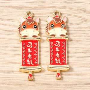 Vue détaillée de pendentifs cheval avec parchemins rouges porte-bonheur pour bijoux