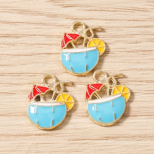 Macro detail of tropical drink enamel pendants with red umbrella and gold alloy loops