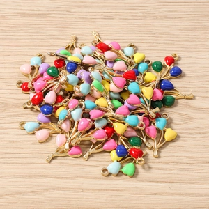 Macro detail of multi-colored cherry-shaped heart alloy pendants on wood background