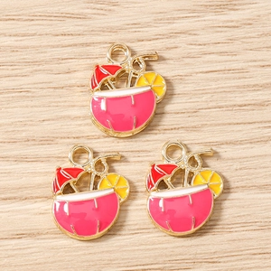 Detail of pink tropical coconut drink pendants with golden alloy frame and colorful enamel