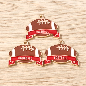 Makro-Detail von drei Rugbyball-Anhängern aus Legierung mit Football-Schriftzug-Charms