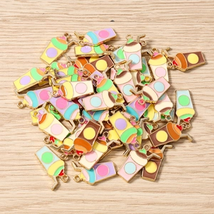 Vue à plat de pendentifs tasses de thé au lait en émail coloré sur fond en bois clair