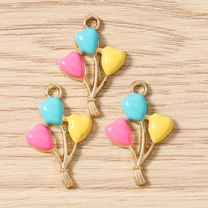 Detailed view of three heart-shaped enamel balloon charms in pastel colors for DIY jewelry