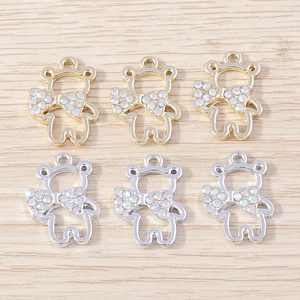 Detailed macro of bear shaped metal charms with rhinestone bows in gold and silver