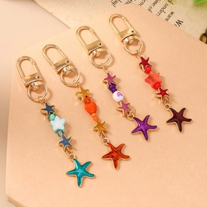 Fashionable starfish beaded keychains in blue, orange, purple, and red with gold clips