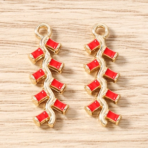 Détail macro de pendentifs pétard rouge avec cadre en métal doré et finition émail