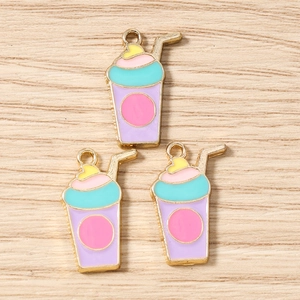 Gros plan de trois pendentifs thé au lait aux couleurs pastel avec bordure dorée pour bijoux