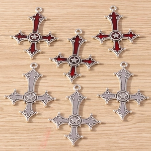 Gedetailleerd beeld van zes gotische kruishangers in zilver metaal met rood en grijs emaille