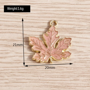 Makroaufnahme eines rosa Emaille-Ahornblatt-Anhängers mit Metalladern für DIY-Schmuck