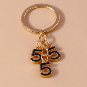 Macro detail of golden keychain with black oil-drop number 5 pendants on a ring