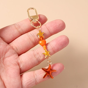 Detailed close-up of ocean-themed starfish keychain with orange beads and gold clasp