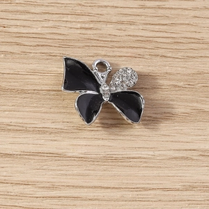 Macro detail of silver butterfly pendant with black enamel and sparkling crystals
