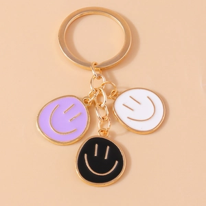 Colorful enamel smiley face pendant keychain with three charms on a golden metal ring