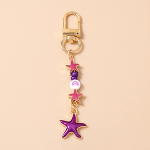 Starfish keychain detail with gold clasp, pink and purple sea stars and moon beads