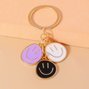 Detail of colorful enamel smiley face charms on a golden keychain keyring