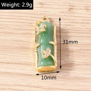 Bamboo shaped emerald green pendant with gold metal edges and butterfly charms