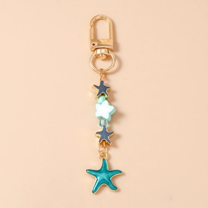 Detail of blue starfish keychain with golden clasp, enamel pendant and colorful beads