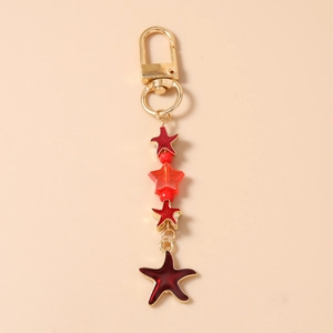 Detail of red and gold star keychain featuring acrylic beads and lobster clasp