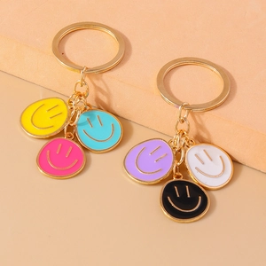 Close-up of golden keychain featuring colorful enamel smiley charms in multiple bright colors