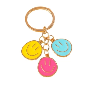 Colorful enamel smiley face keychain with yellow, pink, and blue pendants on gold ring