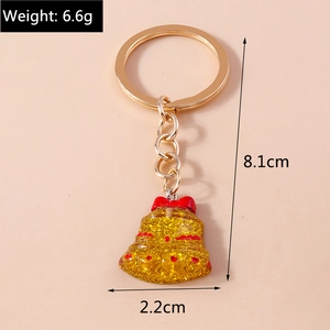 Detail of Christmas bell keychain with golden metal ring and red bow decoration