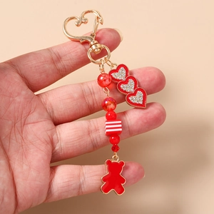 Dettaglio portachiavi orsetto rosso con chiusura a cuore dorata e ciondoli cristallo