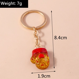Detail showing golden glitter glove keychain dimensions 8.4cm length with red heart