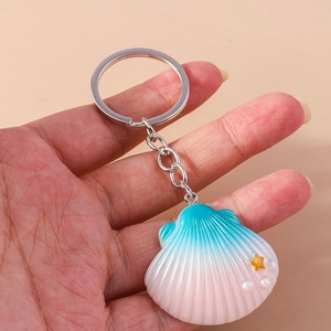 Detail of seashell keychain with pink gradient, gold stars and white pearls