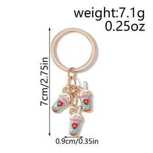 Detail view of colorful enamel milk tea pendants with red hearts on a golden keychain
