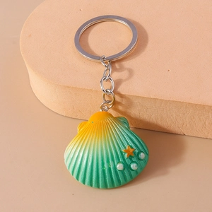 Detailed view of ocean shell keychain with sea star and pearls on a foam display
