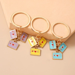 Set of three colorful heart envelope keychains in purple yellow and blue gold plating