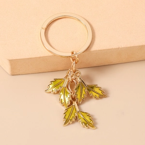 Detailed close-up of yellow enamel leaf charms on a golden metal keychain ring