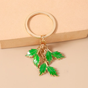 Detail of green enamel leaves with golden alloy veins on a stylish keychain ring